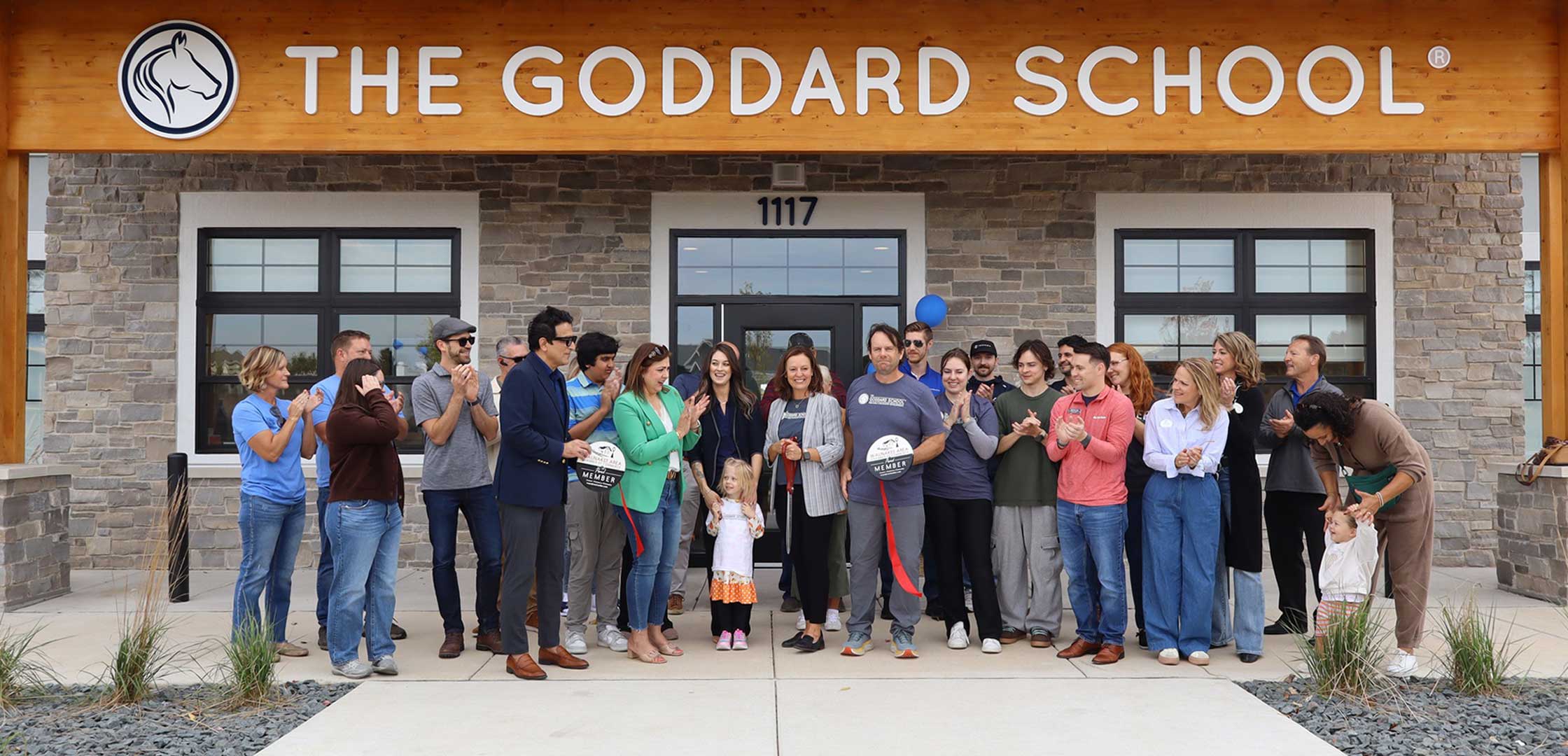 Group of Goddard school employees, owners and Iconica staff celebrating ribbon cutting in front of the early childhood learning center