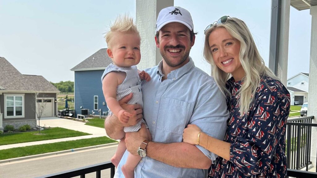 Family photo of the Emmel family holding their young baby and smiling