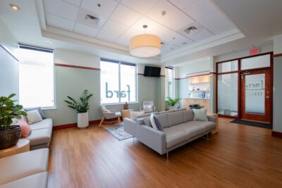 View of dental office waiting room with windows, couches and fard family dental signage