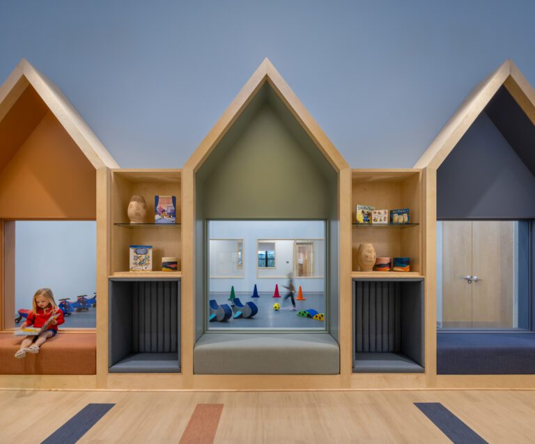 House-shaped reading nooks framing interior view into play gym.