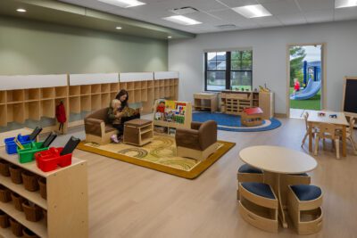 Early childhood classroom with cubbies, reading area, and playground access.