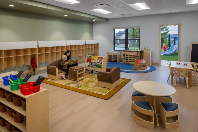 Early childhood classroom with cubbies, reading area, and playground access.