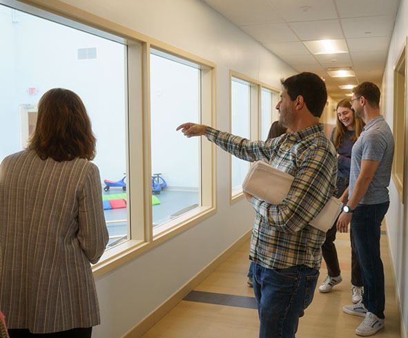 Iconica-Planning Iconica architects looking through window at the gym