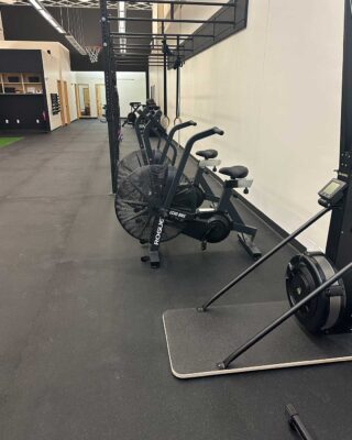 Rehab And Fitness Equipment Area With Rogue Echo Bikes, SkiErg, Rowing Machine, And Pull-up Rig At Forward Therapy