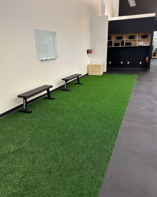 Indoor Turf Training Lane In A Physical Therapy Clinic With Benches And Wall-mounted Whiteboard At Forward Therapy