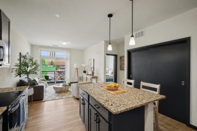 Vicino Apartments open-concept living room and kitchen with granite island and private balcony