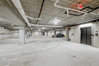 Underground parking garage at Vicino Apartments with resident parking and elevator access