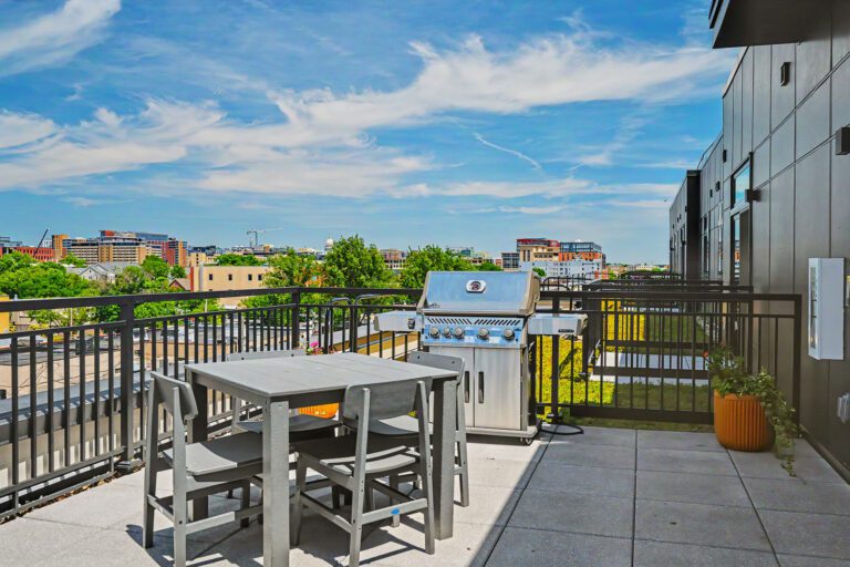 Vicino Apartments rooftop patio with grill, seating, and downtown Madison skyline views