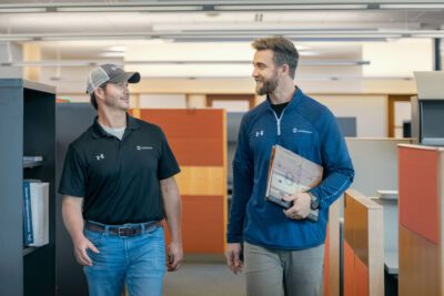 Photo of two Iconica employees talking down a hallway